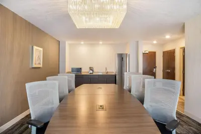 a conference room with a long table and white chairs at Ramada by Wyndham St Paul AB in St. Paul