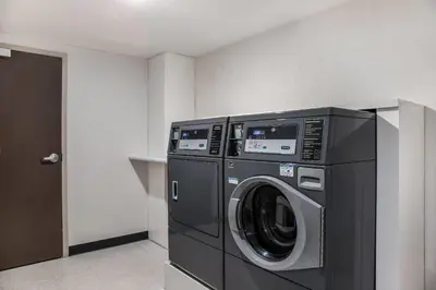 a black washer and dryer in a room at Ramada by Wyndham St Paul AB in St. Paul