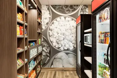 a grocery store aisle with a mural of clouds at Ramada by Wyndham St Paul AB in St. Paul