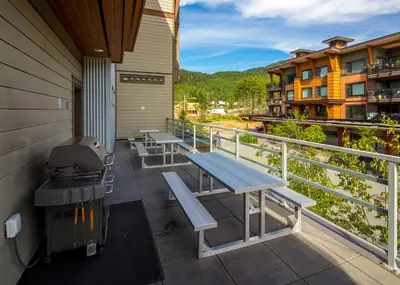 a balcony with a picnic table and a grill at HI Whistler - Hostel in Whistler