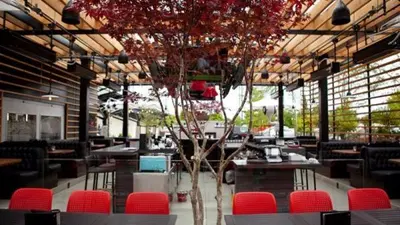 a restaurant with red chairs and a tree in the middle at Coast Hotel & Convention Centre in Langley