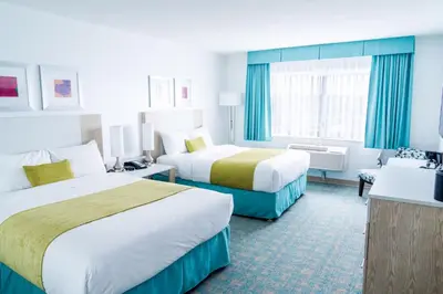 a hotel room with two beds and a couch at Coast Hotel & Convention Centre in Langley