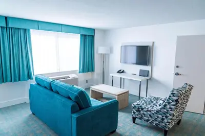 a living room with a blue couch and a chair at Coast Hotel & Convention Centre in Langley