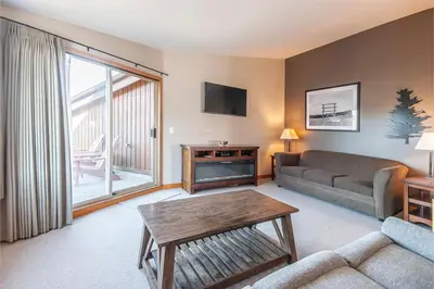 a living room with a couch and a table at Himwitsa Lodge in Tofino