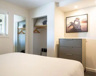 a bedroom with a bed and a dresser at Pacific Sands Beach Resort in Tofino