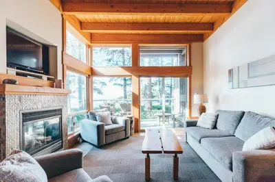 a living room with a couch and a fireplace at Pacific Sands Beach Resort in Tofino