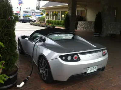 a white lexus rc car is being charged at The Hospitality Inn in Port Alberni