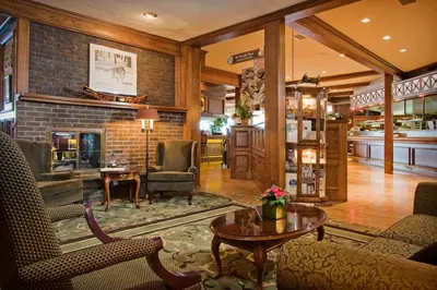 a living room with chairs and a fireplace at Crest Hotel in Prince Rupert