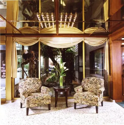 two chairs and a table in front of a building at Crest Hotel in Prince Rupert