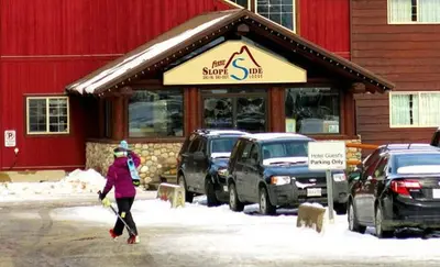 a woman walking in front of a snow shop at Fernie Slopeside Lodge in Fernie
