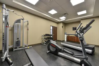 a gym with two tread machines and a treadmill at Siding 16 Lodge in Wetaskiwin