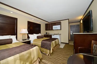 a hotel room with two beds and a flat screen tv at Siding 16 Lodge in Wetaskiwin