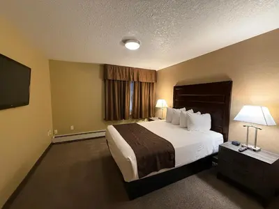 a hotel room with a bed and a television at Siding 16 Lodge in Wetaskiwin