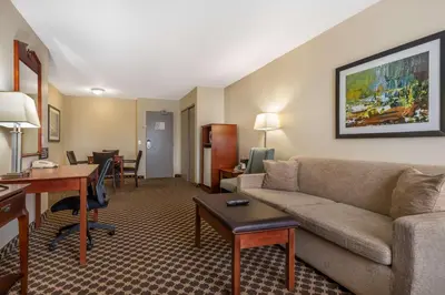 a living room with a couch and a table in a hotel room at Best Western Strathmore Inn in Strathmore