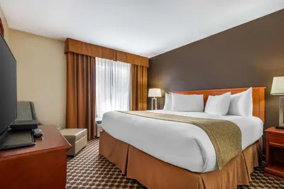 a hotel room with a large bed and a television at Best Western Strathmore Inn in Strathmore
