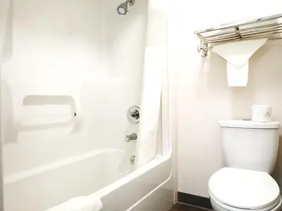 a bathroom with a toilet and a tub and a sink at Days Inn by Wyndham Valemount in Valemount