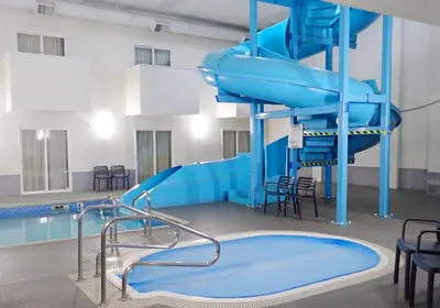 a swimming pool with a blue water slide at Days Inn by Wyndham Valemount in Valemount