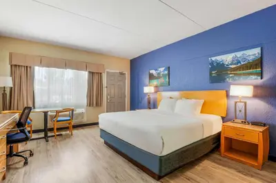 a hotel room with a bed and a desk and a computer at Days Inn by Wyndham Golden in Golden