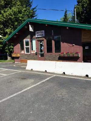 a building with a sign that reads motel office at Copper River Motel in Terrace