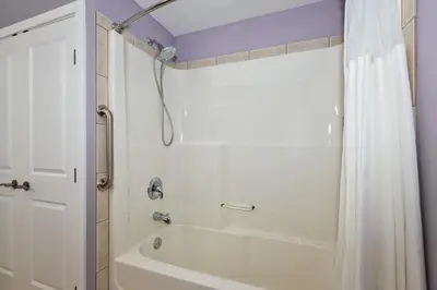 a bathroom with a white tub and a shower at Adela's Bed and Breakfast in West Kelowna