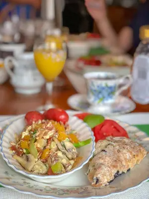 a table with a plate of food on a table at Adela's Bed and Breakfast in West Kelowna