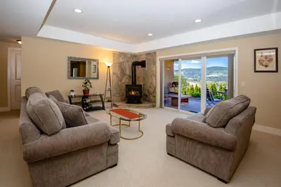 a living room with two chairs and a fireplace at Adela's Bed and Breakfast in West Kelowna