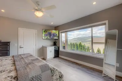 a bedroom with a bed and a large window at Adela's Bed and Breakfast in West Kelowna