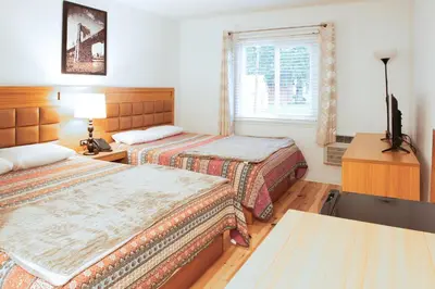 a hotel room with two beds and a window at Pemberton Hotel (Motel) in Pemberton