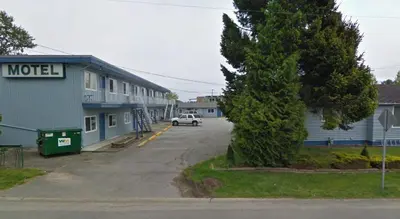 a car parked in a parking lot next to a motel at Beach Grove Motel in Tsawwassen