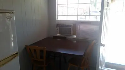 a small kitchen with a table and a window at Holiday House Motel in Penticton