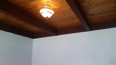 a ceiling light in a room with wooden ceilings at Holiday House Motel in Penticton