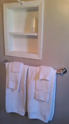 a towel rack with two white towels hanging on it at Holiday House Motel in Penticton
