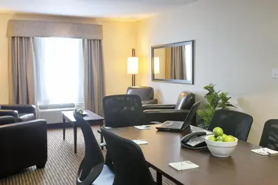 a hotel room with a table and chairs at Vegreville Suites in Vegreville
