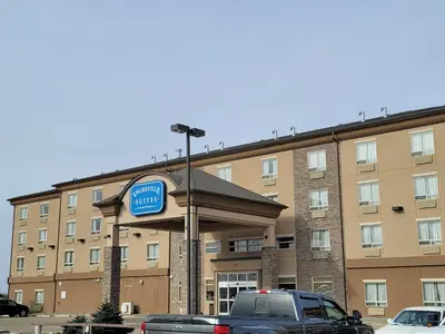 a sign for a hotel in front of a building at Vegreville Suites in Vegreville