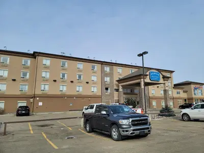 a truck parked in a parking lot in front of a hotel at Vegreville Suites in Vegreville