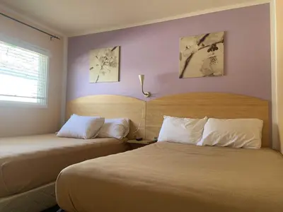 a bedroom with two beds and a window at Waterfront Inn in Penticton