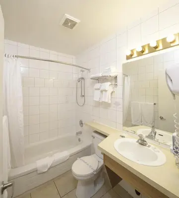 a bathroom with a sink and a toilet and a tub at Waterfront Inn in Penticton