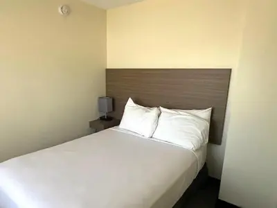 a bedroom with a large bed with white pillows at SureStay by Best Western Smithers in Smithers