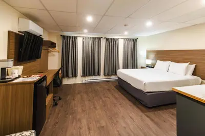 a hotel room with a bed and a television at SureStay by Best Western Smithers in Smithers