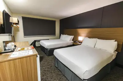 a hotel room with two beds and a flat screen tv at SureStay by Best Western Smithers in Smithers