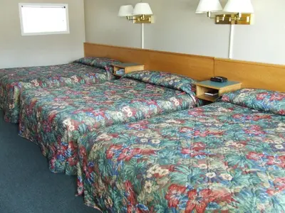 two beds in a hotel room with colorful blankets at Ponderosa Motor Inn in Golden