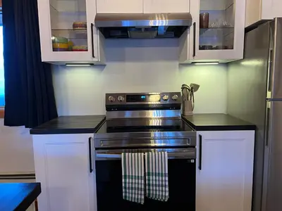 a kitchen with a stove and white cabinets at Winston Lodge in Golden