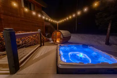 a hot tub sitting on a deck at night at Winston Lodge in Golden