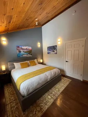a bedroom with a large bed and a wooden ceiling at Winston Lodge in Golden