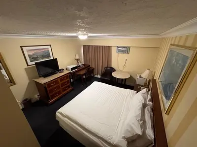 a hotel room with a bed and a desk at Island Travel Inn in Victoria