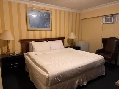 a hotel room with a bed and a chair at Island Travel Inn in Victoria