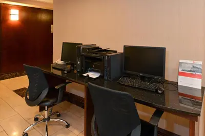an office with three computer monitors on a desk at Holiday Inn Express Edmonton North by IHG in Edmonton