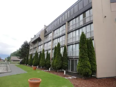 a building with a row of trees in front of it at Oceanfront Suites at Cowichan Bay in Cowichan Bay
