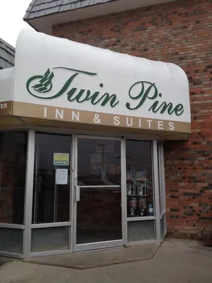 a sign for a runny entrance to a store at Twin Pine Inn & Suites in Hinton