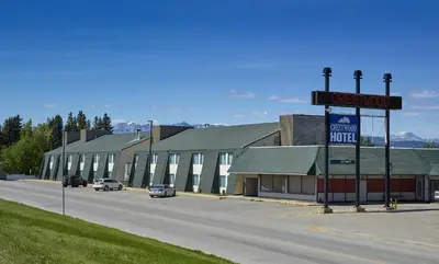 a street with cars parked in front of a building at Crestwood Hotel in Hinton